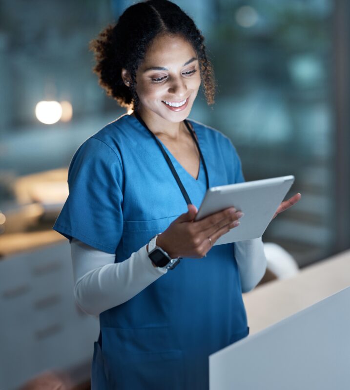 Krankenschwester schaut sich auf einem Tablet eine Pflegesoftware an.